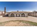 Charming home exterior features arched entryways, a covered carport, and a spacious front yard at 3441 E Taylor St, Phoenix, AZ 85008