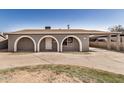 Charming home exterior features arched entryways, a covered carport, and a spacious front yard at 3441 E Taylor St, Phoenix, AZ 85008