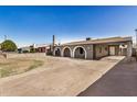 Charming home exterior features arched entryways, a covered carport, and a spacious front yard at 3441 E Taylor St, Phoenix, AZ 85008