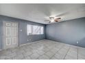 Well-lit living room boasting neutral tile floors and a ceiling fan at 3810 N Maryvale Pkwy # 1059, Phoenix, AZ 85031