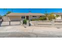 The property's entrance features a secure black metal fence and xeriscape yard, ensuring safety and low maintenance at 3822 W Flower St, Phoenix, AZ 85019