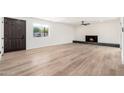 Spacious living room features wood-look flooring, fireplace and modern ceiling fan at 3822 W Flower St, Phoenix, AZ 85019