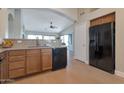 Well-lit kitchen featuring wooden cabinets, granite countertops, and modern black appliances, inviting culinary creativity at 3925 N 160Th Ave, Goodyear, AZ 85395