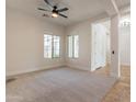 Bright and spacious living room with neutral carpet, ceiling fan, and plenty of natural light at 3971 E Leo Pl, Chandler, AZ 85249