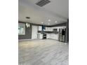 Spacious kitchen with sleek stainless steel appliances, gray walls, and modern lighting at 5029 W Osborn Rd, Phoenix, AZ 85031
