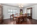 Traditional dining room featuring hardwood floors, a wood table with chairs, and elegant chandelier lighting at 6838 E Belleview St, Scottsdale, AZ 85257