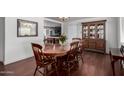 Classic dining room boasts wood floors, a table for six, and a decorative hutch for storage at 6838 E Belleview St, Scottsdale, AZ 85257