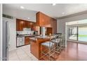 Open kitchen with stainless steel appliances, breakfast bar seating, and a view to the outdoor pool at 6838 E Belleview St, Scottsdale, AZ 85257