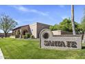 Santa Fe community sign with lush green lawn and well-maintained landscaping at 7673 N Via De Platina Dr, Scottsdale, AZ 85258