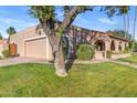 Charming home exterior with a two-car garage, covered porch, and mature trees at 7673 N Via De Platina Dr, Scottsdale, AZ 85258
