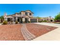 Charming two-story home with a well-manicured front yard, a brick walkway, and a two car garage at 7749 W Hearn Rd, Peoria, AZ 85381