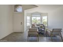 Bright living room featuring large windows, neutral tones, and stylish furniture at 8370 W Audrey Ln, Peoria, AZ 85382
