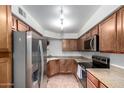 Well-lit kitchen featuring stainless steel appliances, stone countertops, and light brown wooden cabinets at 8787 E Mountain View Rd # 1087, Scottsdale, AZ 85258