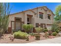 Two-story home boasts desert landscaping, a neutral color palette, and a three-car garage at 9661 E Glencove Cir, Mesa, AZ 85207