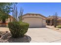 Charming single-story home featuring a two-car garage, desert landscaping, and a well-maintained lawn at 9717 W Purdue Ave, Peoria, AZ 85345