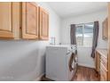 A conveniently located laundry room offers storage cabinets, washer and dryer, plus natural light at 9801 N 56Th Dr, Glendale, AZ 85302