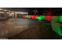 Inviting backyard pool features an outdoor lounge area and festive red and green holiday lighting at 1231 E Sunburst Ln, Tempe, AZ 85284