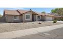 Well-maintained home with desert landscaping, concrete driveway and walkway to the front door at 1231 E Sunburst Ln, Tempe, AZ 85284