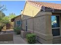 Side exterior view of a tan, single-story home featuring a tile roof and well-maintained landscaping at 1309 W Calle Del Norte --, Chandler, AZ 85224