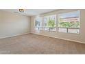 Bright, carpeted living room with large windows offering ample natural light at 15936 W Kino Dr, Surprise, AZ 85374