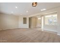 Open-concept living room with neutral walls, carpet, and view to front entrance at 15936 W Kino Dr, Surprise, AZ 85374