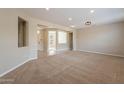 Spacious living room features neutral paint and carpet, with an open floor plan at 15936 W Kino Dr, Surprise, AZ 85374
