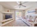 Comfortable living room with a plush sofa, ceiling fan, built-in shelving, and access to a private balcony at 16631 E El Lago Blvd # 208, Fountain Hills, AZ 85268