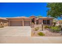 Charming home featuring a tile roof, three-car garage, and professionally landscaped desert-style yard at 25633 N 71St Dr, Peoria, AZ 85383