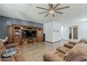 Spacious living room features a ceiling fan, wood flooring, and custom entertainment center at 3173 N Clanton St, Buckeye, AZ 85396