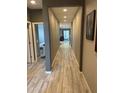 Long hallway featuring hardwood floors, neutral walls, and access to various rooms at 3211 W Pollack St, Phoenix, AZ 85041