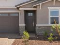 Close up of front door with sidelight and brick accents on a single-story home at 5573 S 246Th Ave, Buckeye, AZ 85326