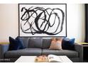 Comfortable gray sofa with colorful throw pillows and modern wall art at 6012 W Flower St, Phoenix, AZ 85033