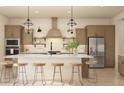 Stylish kitchen features modern cabinetry, stainless steel appliances, a large island with seating, and elegant pendant lighting at 667 E Brown Way, San Tan Valley, AZ 85140