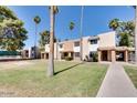 Inviting townhomes featuring well-maintained lawns, mature palm trees and convenient walkways at 7126 N 19Th Ave # 224, Phoenix, AZ 85021