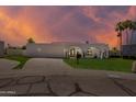 Modern white home featuring red tile roof and lush green lawn at sunset at 7328 E Laredo Ln, Scottsdale, AZ 85250