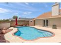 Backyard featuring a sparkling pool surrounded by a brick border, desert landscaping, and privacy fence at 7649 W Dahlia Dr, Peoria, AZ 85381