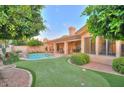 The backyard boasts a private pool, putting green, mature trees, and covered patio at 8036 E Mercer Ln, Scottsdale, AZ 85260