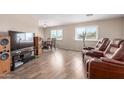 Inviting living room featuring wood-look floors and large windows that fill the space with natural light at 8730 E Dewan Ave, Mesa, AZ 85208