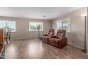Cozy living room with wood-look flooring and large windows, creating a bright and inviting space at 8730 E Dewan Ave, Mesa, AZ 85208