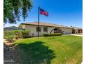 Exterior view of a home with a lush green lawn and an American flag waving proudly at 9436 N 41St Dr, Phoenix, AZ 85051