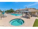 Community pool and spa area including a covered seating area on a sunny day at 955 E Knox Rd # 137, Chandler, AZ 85225