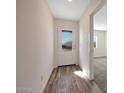 Bright entryway with wood-look floors, and a front door with a decorative glass window at 1050 W West Virginia Ave, Florence, AZ 85132