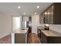 This modern kitchen has stainless steel appliances, granite countertops, and wood-look flooring at 1050 W West Virginia Ave, Florence, AZ 85132