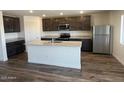 Modern kitchen featuring stainless steel appliances, a spacious island, and sleek gray cabinetry at 1091 W West Virginia Ave, Florence, AZ 85132