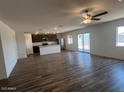 Open-concept living room and kitchen featuring luxury vinyl flooring and abundant natural light at 1091 W West Virginia Ave, Florence, AZ 85132