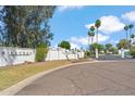 Welcoming entrance to a private adult community with beautifully maintained landscaping and secure gate access at 113 E Boca Raton Rd, Phoenix, AZ 85022