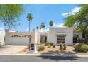 Attractive home with a two-car garage, desert landscaping, and stylish black and white striped awnings at 113 E Boca Raton Rd, Phoenix, AZ 85022