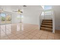 Bright living room featuring tile floors, a ceiling fan, and stairway access to the second floor at 11710 W Paradise Dr, El Mirage, AZ 85335