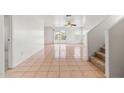 Bright living room featuring tile floors, a ceiling fan, and sliding glass doors that lead to backyard at 11710 W Paradise Dr, El Mirage, AZ 85335