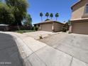 Tan home showcasing attached garage and desert landscaping at 12938 W Alvarado Rd, Avondale, AZ 85392